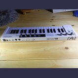 Bílá klaviatura s 37 klávesami. Na přední hraně je nápis KEYSTEP 37 a pod ním text CONTROLLER & SEQUENCER, v pravém rohu je logo (A.). Vlevo na horní…