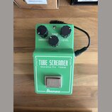 Zelený efekt pedál s nápisy TUBE SCREAMER, Overdrive Pro TS808 a logem Ibanez. Na horní straně jsou tři černé ovládací knoflíky s popisky OVERDRIVE,…