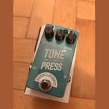 Tyrkysový efekt pedál s bílými nápisy. Na horní straně jsou tři černé oválné knoflíky s popisky VOLUME, BLEND a SUSTAIN. Uprostřed je velký bílý nápi…