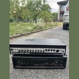 Dvě černé basové komba v rackovém provedení naskládaná na sebe. Horní zařízení má nápis BACKLINE 600, logo GK a text 900 WATT BASS AMPLIFIER. Spodní…