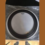 Bílá bubnová blána s černým plastovým prubcem. Na horní části je logo REMO a pod ním nápis AMBASSADOR COATED. V pravém dolním rohu je malý kulatý ští…