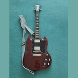Elektrická kytara s červeným lakem a černým pickguardem. Na hlavě hmatníku je bílé logo Epiphone. Kytara má dva humbuckery, čtyři ovládací knoflíky a…