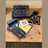 Na fotografii jsou dva černé syntezátory s nápisem Moog, z nichž na spodním je uveden model MOTHER-32 SEMI MODULAR ANALOG SYNTHESIZER. Součástí sady…