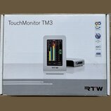 Krabice s nápisem TouchMonitor TM3 a logem RTW. Na obrázku je zobrazen stříbrný přístroj s displejem, který zobrazuje barevnéy měřiče úrovně a ovláda…