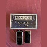 Na fotografii je krabička a dvě součásti příslušenství. Na krabici je nápis ROCKBOARD® by WARWICK a ručně napsaný text PEDALSAFE PICK BOX. Vedle krab…