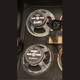 Dva reproduktory s černým papírem a šedými kovovými rámy, které vykazují známky opotřebení povrchu. Na obou jsou nápisy BLACK SHADOW, MESA BOOGIE a C…
