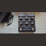 Kytarový efekt StompMan značky Hughes & Kettner v černé barvě. Na horní straně jsou nápisy Speaker out, Power, Solo Vol., Return, Send / Line out a I…
