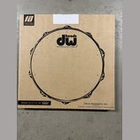 Kartonová krabice s černým potiskem stylizovaného bubnového obruče. Uprostřed je logo „dw heads“ a pod ním nápis „THE DRUMMER'S CHOICE®“. V levém hor…