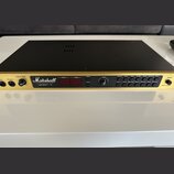 Zlatý rackový předzesilovač s černým krytem. Na čelním panelu je bílé logo Marshall a nápisy VALUE MIDI PRE-AMP JMP-1. Zařízení má červený digitální…