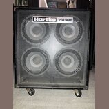 Černý basový reproduktor s kovovou mřížkou, který je osazen čtyřmi membránami. V horní části je umístěno logo Hartke a nápis HD50B. Celý přístroj sto…
