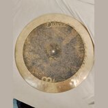 Kruhový mosazný činel s výrazně patinovaným a tmavším středem. V horní části je vidět nápis Byzance a pod ním menší text Made in China. Povrch činelu…