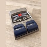 Šedý kytarový procesor s nápisem RP50 a MODELING GUITAR PROCESSOR. Zařízení má červený displej, řadu ovládacích tlačítek a dvě modrává pedály s bílým…