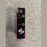 Červené audio rozhraní s nápisem Scarlett Solo. Na přední straně jsou dva otočné knoflíky GAIN, jeden velký knoflík MONITOR a tlačítka 48V, AIR, INST…