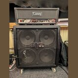 Fotografie zobrazuje kytarový stack složený z komba a boxu. Horní část tvoří zesilovač značky Laney s viditelným ovládacím panelem a přepínačem POWER…