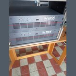 Dvě černé rackové koncové stupně s červenými vodorovnými liniemi na předním panelu. Na obou zařizeních je bílý nápis „Ev Q66 PROFESSIONAL AMPLIFIER“.…