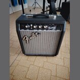 Černý kytarový kombo zesilovač s šedou textilní maskou reproduktoru. Na předním panelu je nápis Fender a označení modelu Frontman 10G s doplňkem FEND…