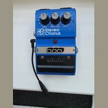 Modrý kytarový efekt s nápisem FX Stereo 65 Chorus. Na horní části jsou tři ovládací knoflíky s popisky SPEED, DELAY TIME a DEPTH. Spodní část obsahu…
