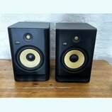 Dva černé studiové monitory s žlutými membránami basových reproduktorů. Na přední straně každého reproduktoru je umístěno logo KRK SYSTEMS. Povrch sk…