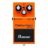 Oranžový kytarový efekt s nápisy Distortion a DS-1w. Na horní části jsou tři ovládací knoflíky s popisky TONE, LEVEL a DIST, kontrolka CHECK a přepín…