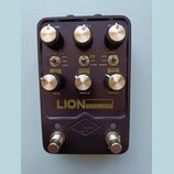 Tmavě hnědý kytarový pedál s nápisem LION 68 SUPER LEAD AMP a logem UA v kosočtverci. Horní řada obsahuje tři otočné knoflíky s popisky VOLUME I, VOL…