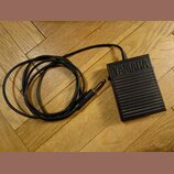 Černý sustain pedál z plastu s žebrovaným povrchem. Na horní části je vyraženo logo YAMAHA. K pedálu vede černý kabel zakončený 6,3mm jack konektorem.