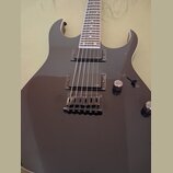 Černá elektrická kytara s dvojitým výřezem v korpusu. Nástroj je vybaven dvěma humbuckery s nápisem EMG a černým mostem. Na korpusu jsou umístěny dva…