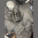 Na fotografii je zmotaný šedý kabel s připojeným černým ovládacím boxem. Box obsahuje 12 tlačítek a nápisy „SMLART“, „TX“ a „RX“. Povrch kabelu i box…