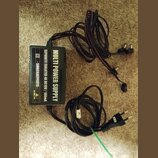 Černý napájecí adaptér s nápisem MULTI POWER SUPPLY a SEPARATE ISOLATED 4X DC10V / 100mA. Na boku je uveden text - SMRCKAEFFECTS - a označení DC 230V…