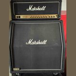 Kytarový kombozesilovač složený z hlavy a boxu značky Marshall. Na hlavě je bílé logo Marshall a nápis JCM 800 LEAD SERIES. Box má černou textilní př…