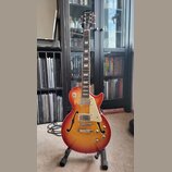 Polodupatá elektrická kytara s trupem v červeno-žlutém sunburst provedení a bílým pickguardem. Na hlavě hmatníku je bílý nápis Epiphone a červené log…