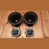 Dva černé tubové reproduktory s kruhovým hornem a čtyři montážními otvory. Pod nimi jsou dva magnetické členy s nápisy SICA loudspeakers a MADE IN IT…