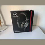 Černá kartonová krabice s červeným pásem na hraně. Na přední straně je fotografie černých sluchátek s logem a nápisem AUSTRIAN AUDIO. Dole je uveden…