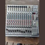Stříbrný mixážní pult s nápisem EUROBACK UR244FX-PRO. Zařízení obsahuje několik vstupních kanálů s modrými a červenými otočnými knoflíky, posuvníky h…