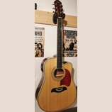 Akustická kytara s přístupem pro praváky, přírodní barva těla a tmavě hnědá hlava. Na hlavě je viditelné logo Epiphone. Kytara má červený pickguard a…