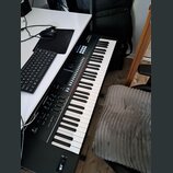 Černý klávesový syntetizátor s bílými a černými klávesami. Na horním panelu je vidět nápis „Roland JUNO-D“. Přístroj obsahuje řadu tlačítek, posuvník…