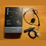 Na fotografii je černý hlavový mikrofon s černou molovou větřnicí a doprovodná krabice. Na krabici jsou nápisy MICROMIC THE ORIGINAL, C 520 VOCAL a l…