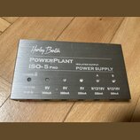 Stříbrný napájecí zdroj s kovovým povrchem. Na horní straně je nápis Harley Benton, POWERPLANT ISO-5 PRO a ISOLATED OUTPUT POWER SUPPLY. Zařízení má…