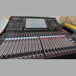 Černý digitální mixovací pult s červenými detaily na hranách. V horní části je nápis DiGiCo SD9, displej a ovládací prvky. Spodní část obsahuje velké…
