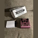Růžový efekt pedál s nápisy DIG dual digital delay a strymon. Na horní straně jsou čtyři černé ovládací knoflíky, dva spínače s nápisy TAP a BYPASS a…