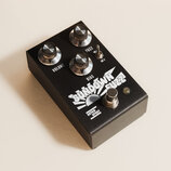 Černý efekt pedál s nápisy VOLUME, FUZZ a BIAS. Na spodní části je bílý grafický symbol slunce a nápis SUNDOWN FUZZ s malým logem RETRO SPRINT. Zaříz…