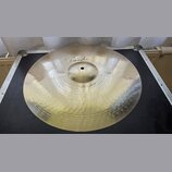 Kovový činel v zlatavé barvě s viditelným kovánívým povrchem. Na povrchu je nápis „Paiste“ a níže označení „Full Crash 18"“. Činel je položen na čern…
