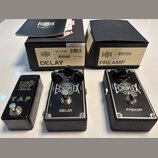 Tři černé kytarové efekty v kovovém provedení s texturovaným spodkem. První pedál má nápisy ERNIE BALL a TAP, prostřední nápisy ECHOPLEX a DELAY s ov…