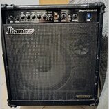 Černý kytarový kombo zesilovač značky Ibanez. V horní části je ovládací panel s nápisy GAIN, BASS, MIDDLE, TREBLE, PRESENCE a VOLUME, dále vstupy CD…