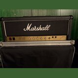 Kytarový zesilovač Marshall v černé texturované krytince s bílým lemováním. Na předním panelu je nápis JCM 800 LEAD SERIES a řada ovládacích knoflíků…