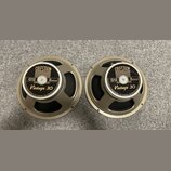 Dvě identické reproduktory s kovovým rámem v béžovém odstínu. Na středovém krytu je černý štít s nápisy CELESTION LOUDSPEAKERS, G12, 8ohms a Vintage…