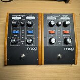 Dvě efektové pedály Moog v černém provedení s dřevěnými bočními panely. Levý pedál nese nápisy moogerfooger RING MODULATOR a logo moog, pravý pedál n…
