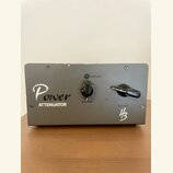 Šedý kovový box s nápisem Power ATTENUATOR a logem HB v pravém dolním rohu. Na přední straně jsou dva černé otočné ovladače s popisky Line Level a SP…