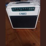 Bílý kytarový kombozesilovač s černou textilní maskou reproduktoru. Na předním panelu je nápis Ibanez TS015 a sekce s označením TUBE SCREAMER. Ovláda…