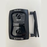 Černý bezdrátový přijímač s dvěma anténami. Na horní části je nápis RELAY G50 RX512 RECEIVER a ve spodní části logo LINE 6. Zařízení obsahuje dva ovr…