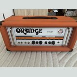 Kytarový kombozesilovač v oranžovém texturovaném potahu s černou rukojetí. Na bílém předním panelu je velký nápis ORANGE a označení modelu TH30. Pane…